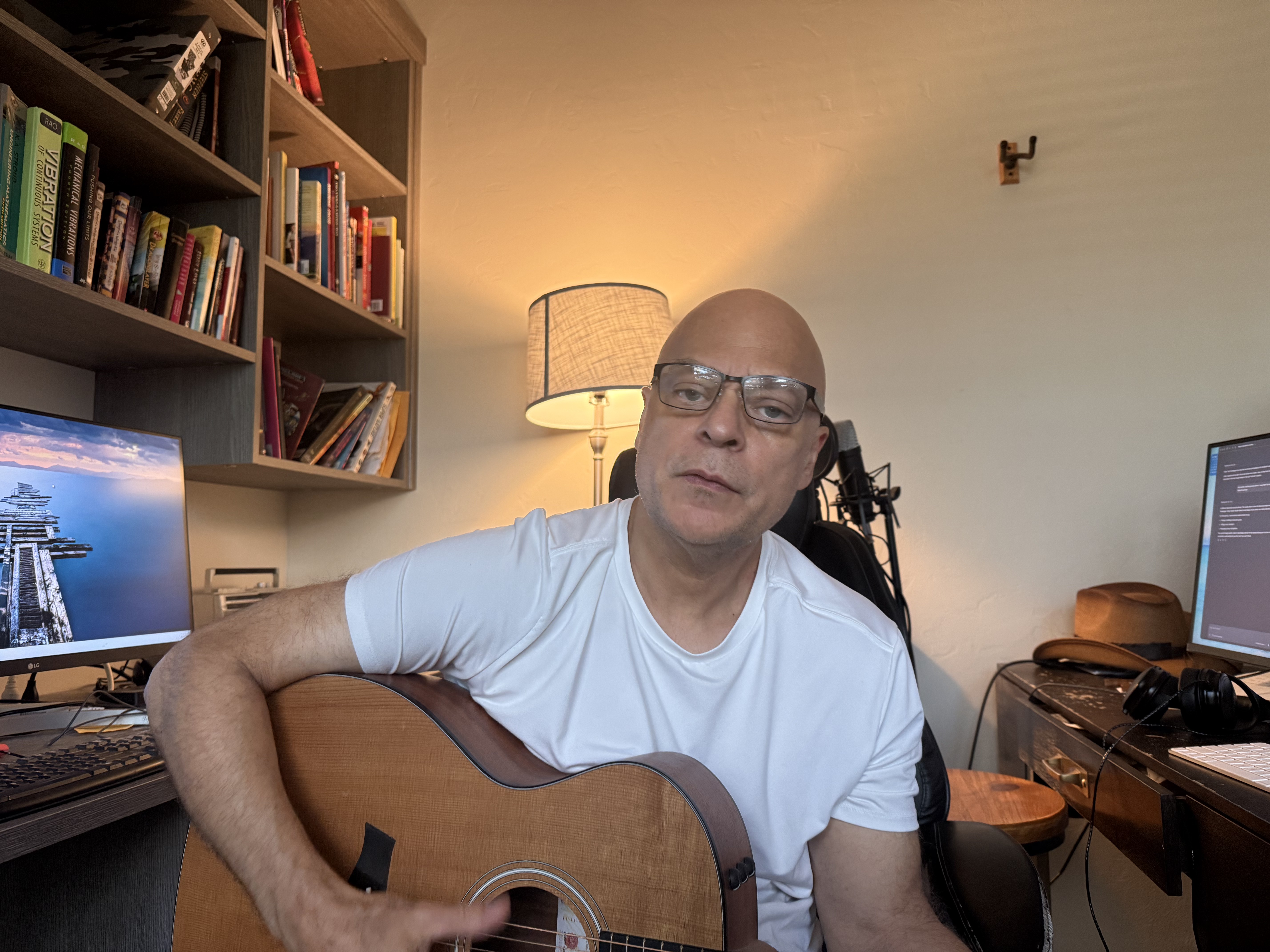 Joe Stroffolino playing acoustic guitar in his home music studio